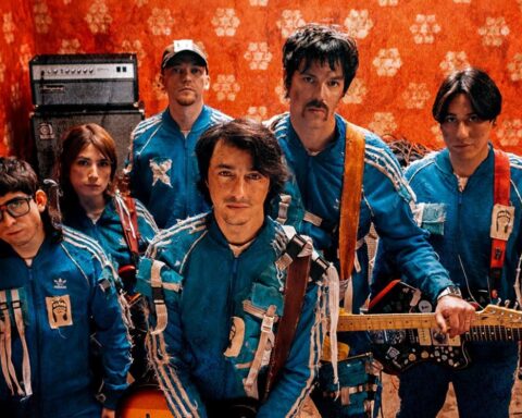 todos los integrantes de la banda chilena plumas vestidos con uniformes azules en un estudio de grabación