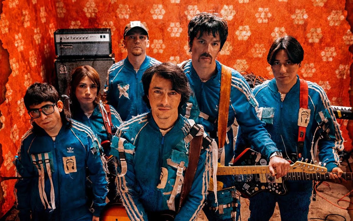 todos los integrantes de la banda chilena plumas vestidos con uniformes azules en un estudio de grabación