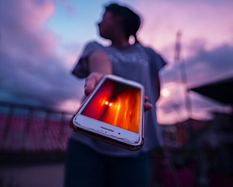 persona silueta mostrando ceular