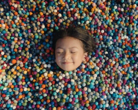 I took this in a felt ball factory while I was shooting a documentary video. This small girl was curious about my camera, so while I was on a break I took her picture. I saw these felt balls lying on the ground and had the idea to photograph the little girl there, coveredwith the colourful material and asking her to close her eyes as if she were asleep.